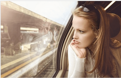 Tyttö katsoo ulos junan ikkunasta
