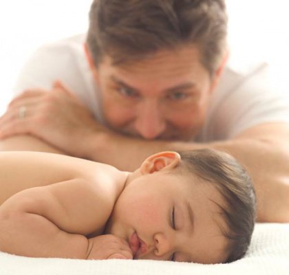 father watching sleeping baby