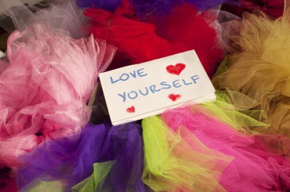 Notecard reading "Love Yourself" among colored tissue paper