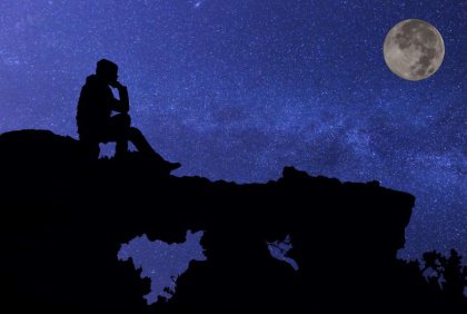 Silhouette of a man under a full moon