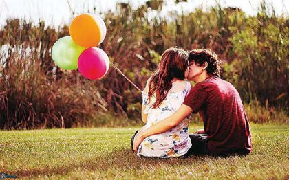 Par kysser på græsplæne som eksempel på at være i det rigtige forhold