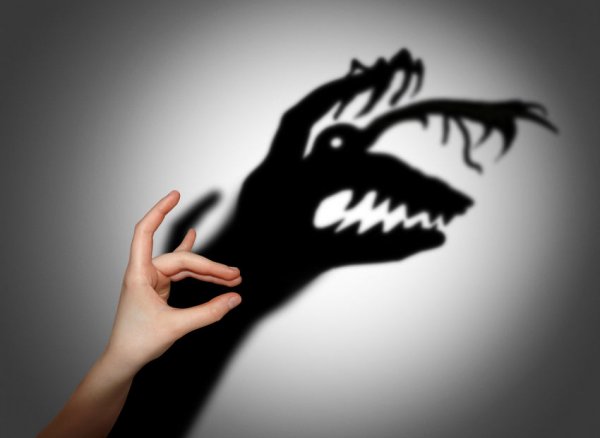 Hand gör en skuggdocka som framstår som ett överdrivet monster