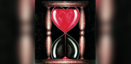 Hour glass shaped like heart with red sand