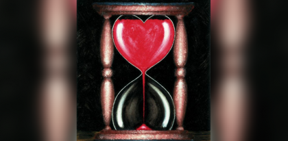 Hour glass shaped like heart with red sand 