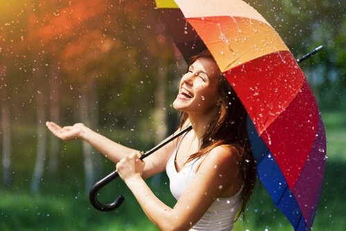 Lycklig kvinna under paraply