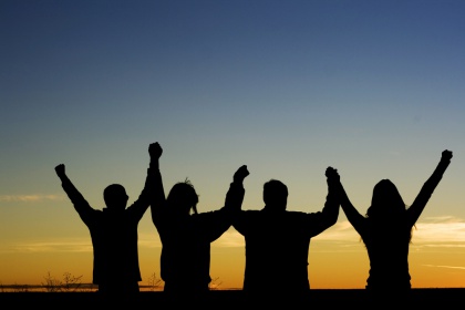 4 People Cheering at Sunset