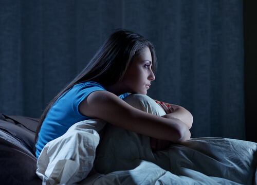 girl sitting awake in bed insomnia