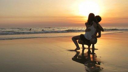 man and woman caressing beach sunset men
