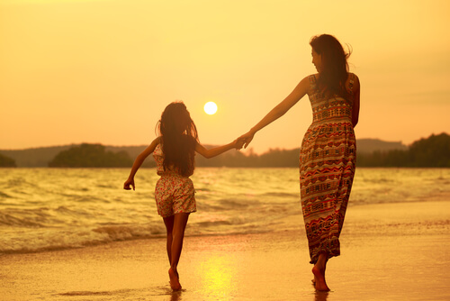 mother and daughter walking on the beach