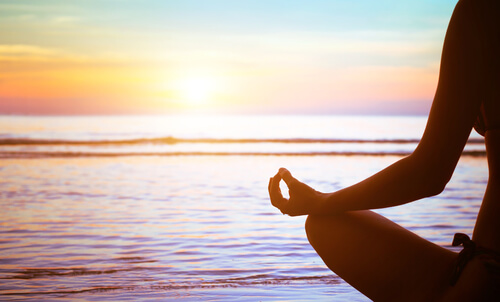 person meditating next to the ocean mindfulness