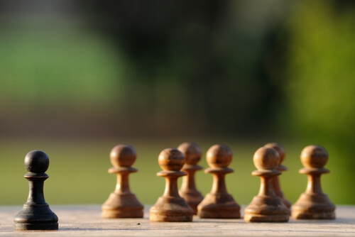 chess pieces white together black alone