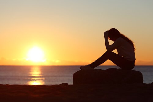 sad woman with her head on her knees