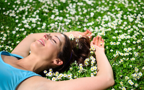 woman talying on a field of daisies