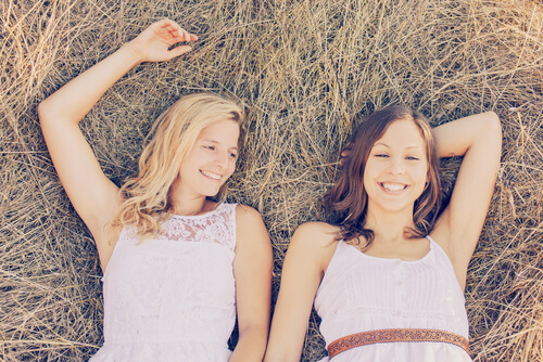 young sisters laying on the grass enjoying