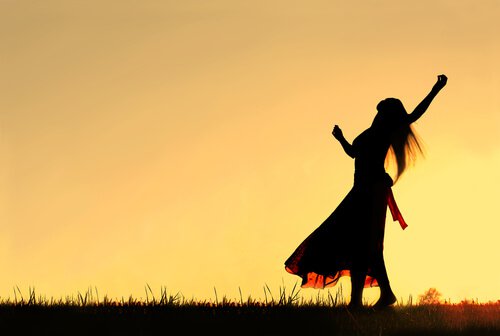 Kobieta tańczy o zachodzie słońca