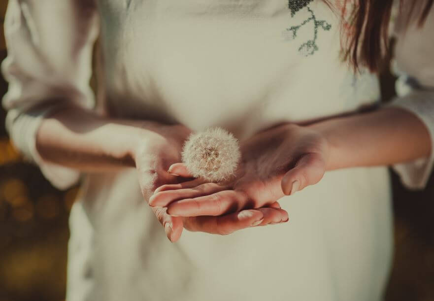 girl holding dandelion humility