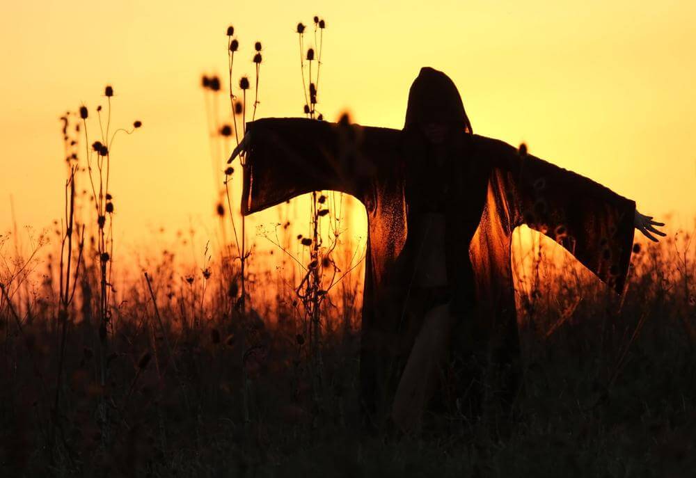 woman with cape at sunset
