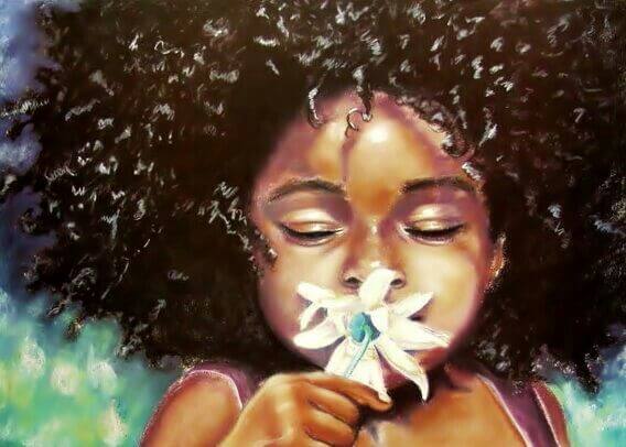 girl of color smelling a flower