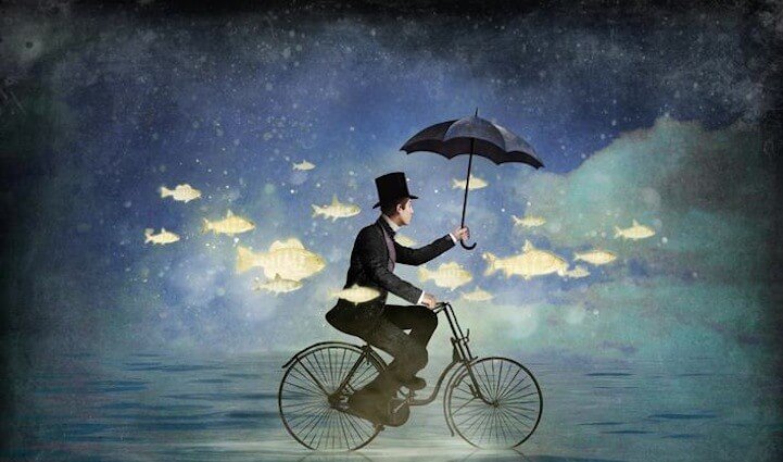 man on bike surrounded by fish