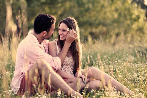 boy putting a flower in his girlfriend's hair