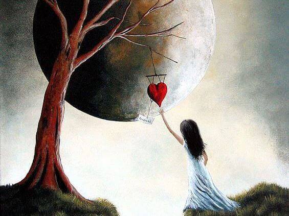 girl grabbing a heart hanging from a tree
