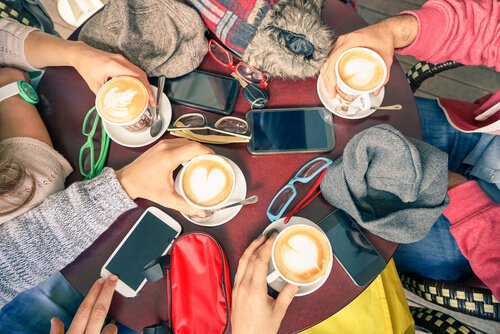 group of friends drinking coffee with cell phones on the table