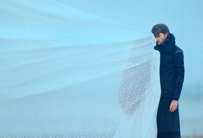 man in front of a woman with a white veil