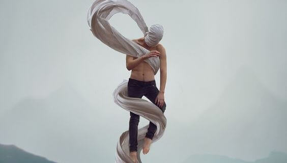 man intertwined in sheets