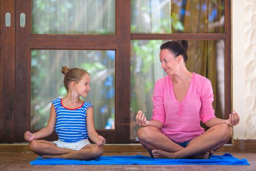 mother teaching her daughter to meditate