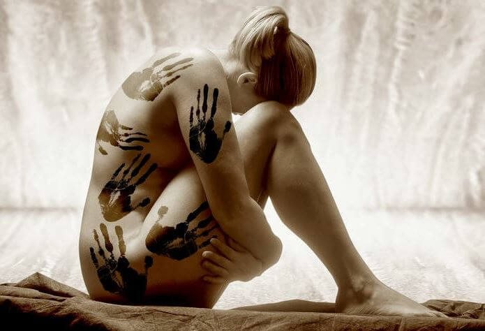 naked woman covered in hand prints