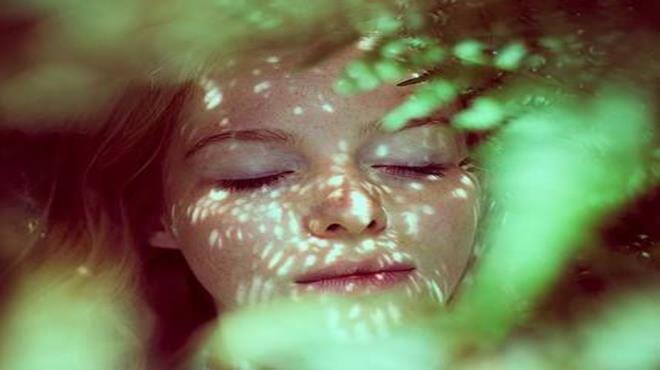 smiling woman wrapped in ferns