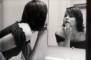 woman doing make up in mirror