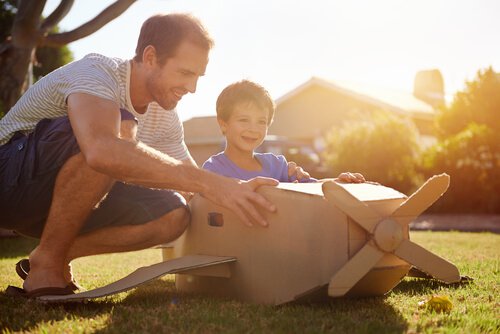 Boy in Cardboard Plane next to Dad