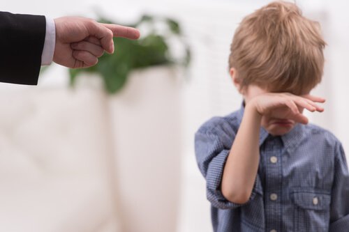 boy crying being pointed at by his father
