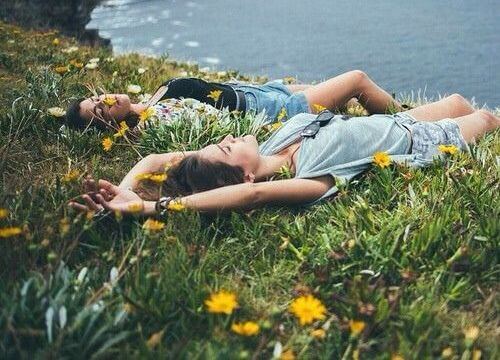 girls laying in field of flowers