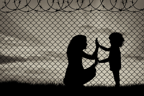 mother and daughter near a barbed wire fence