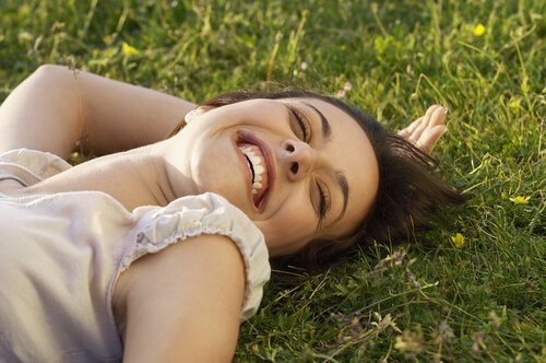 smiling woman laying on a lawn