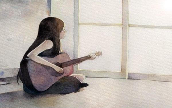 woman with a guitar sitting on the ground