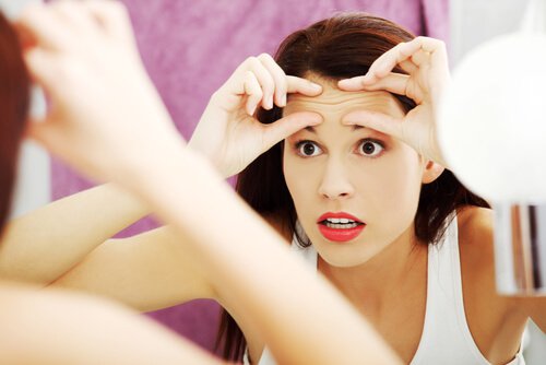 Woman Looking for Wrinkles in Mirror