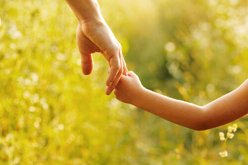 child holding parent's hand