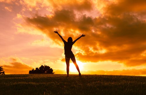 girl with arms stretched sunset