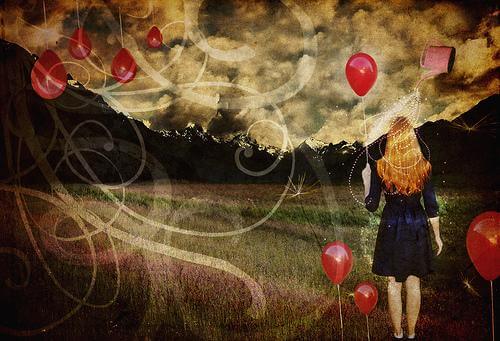 woman in a field holding balloons