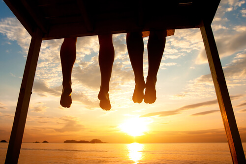 Friends Watching Sunset Legs Dangling