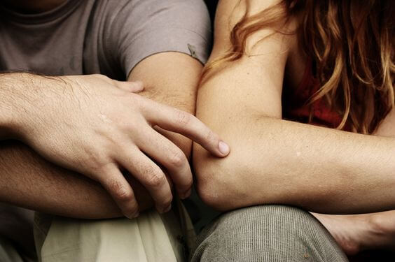 A man touching a woman's arm.