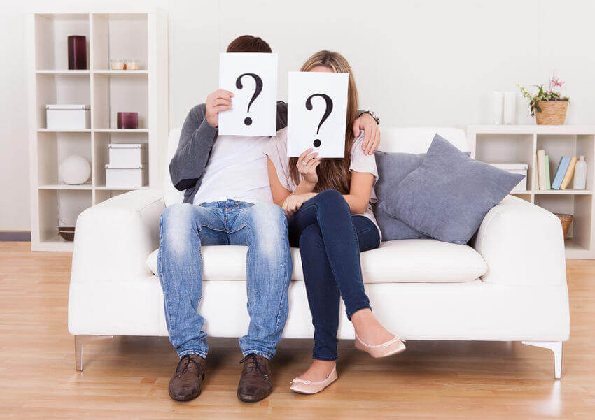 couple-holding-question-mark-signs