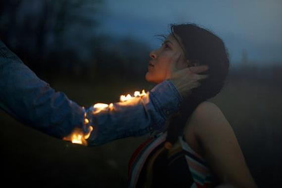 man-with-arm-on-fire-touches-womans-face