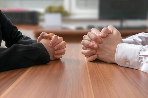 two-pairs-of-hands-on-a-table