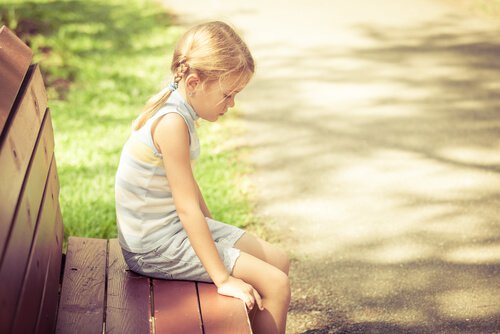 blonde-girl-sitting-on-a-bench-sad
