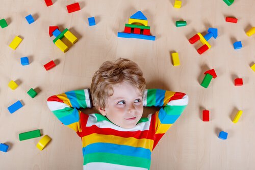 boy-laying-down-surrounded-by-pieces-of-toys