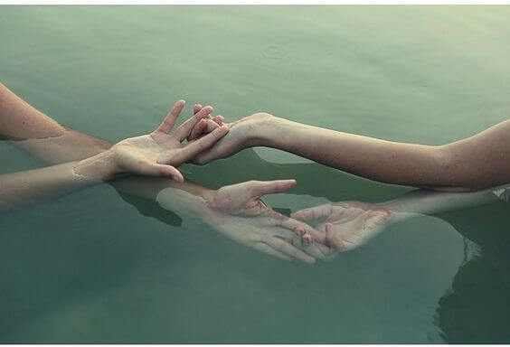 Twee paar handen op het water